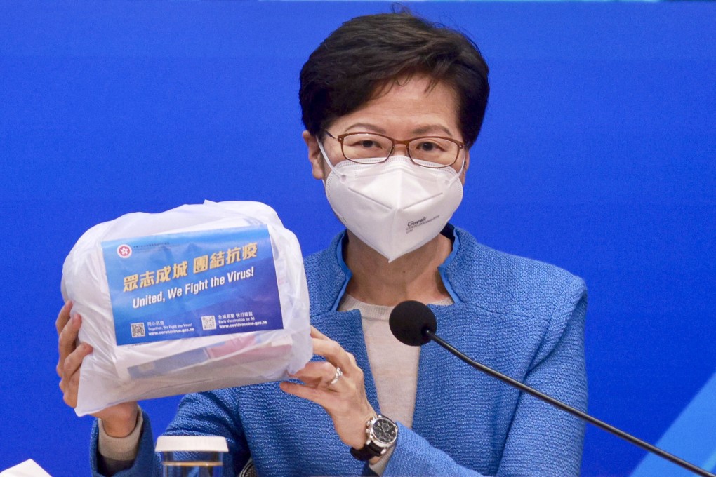 Chief Executive Carrie Lam displays the kits the government will send out to households. Photo: Pool/ SCMP