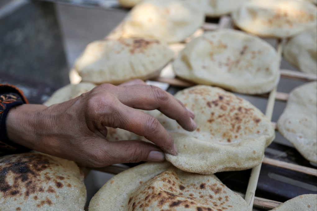 A woman checks bread in Cairo. In Egypt, bread is a staple food for tens of millions and soaring prices have sparked serious unrest in the past. Photo: Reuters
