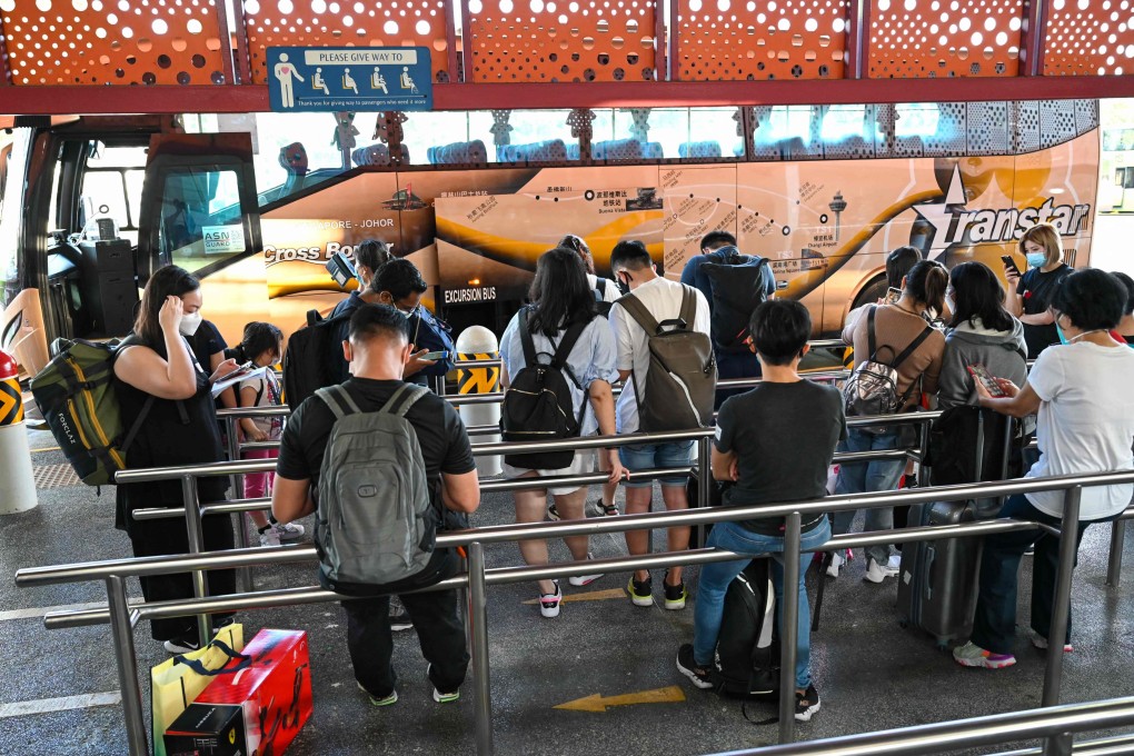 People in Singapore board a bus under the vaccinated travel lane for cross-border passengers to Malaysia’s Johor state in November 2021. Photo: AFP