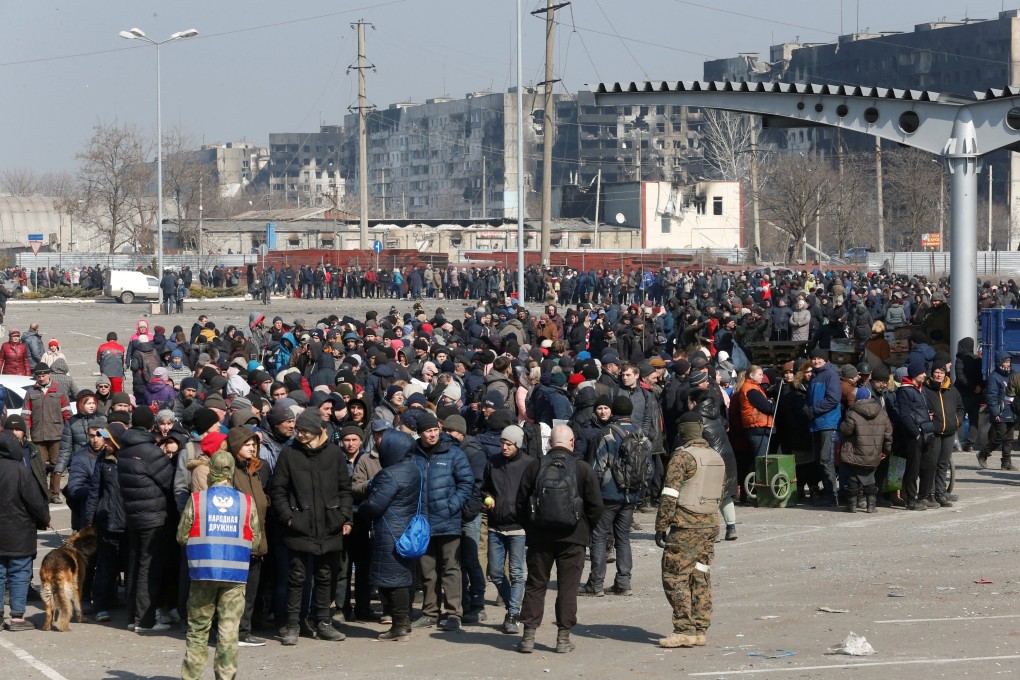 People stand in a long queue during the distribution of humanitarian aid near a damaged store of wholesaler Metro in the course of Ukraine-Russia conflict in the besieged southern port city of Mariupol. Photo: Reuters