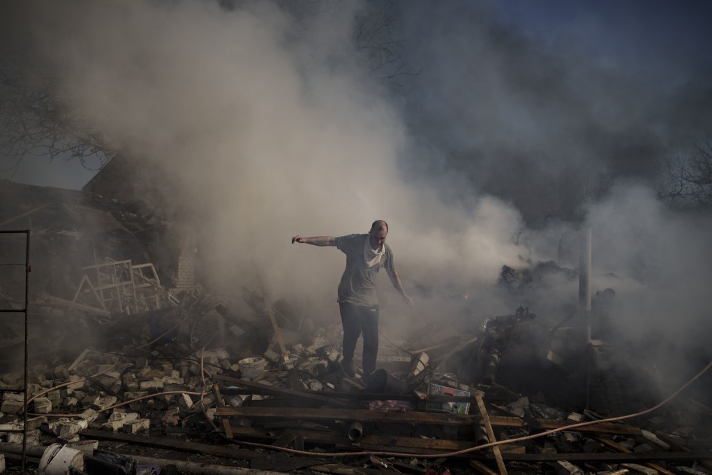 A man walks on the debris of a burning house, destroyed after a Russian attack in Kharkiv, Ukraine on March 24, 2022. Photo: AP Photo