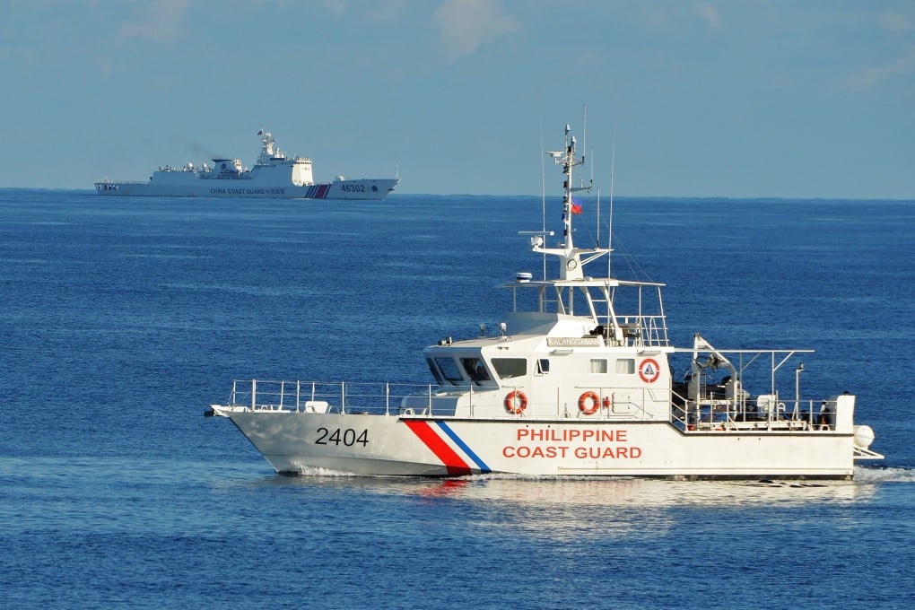 A Philippine coastguard ship sails past a Chinese coastguard vessel near Scarborough Shoal in the South China Sea. Photo: AFP/Getty Images/TNS