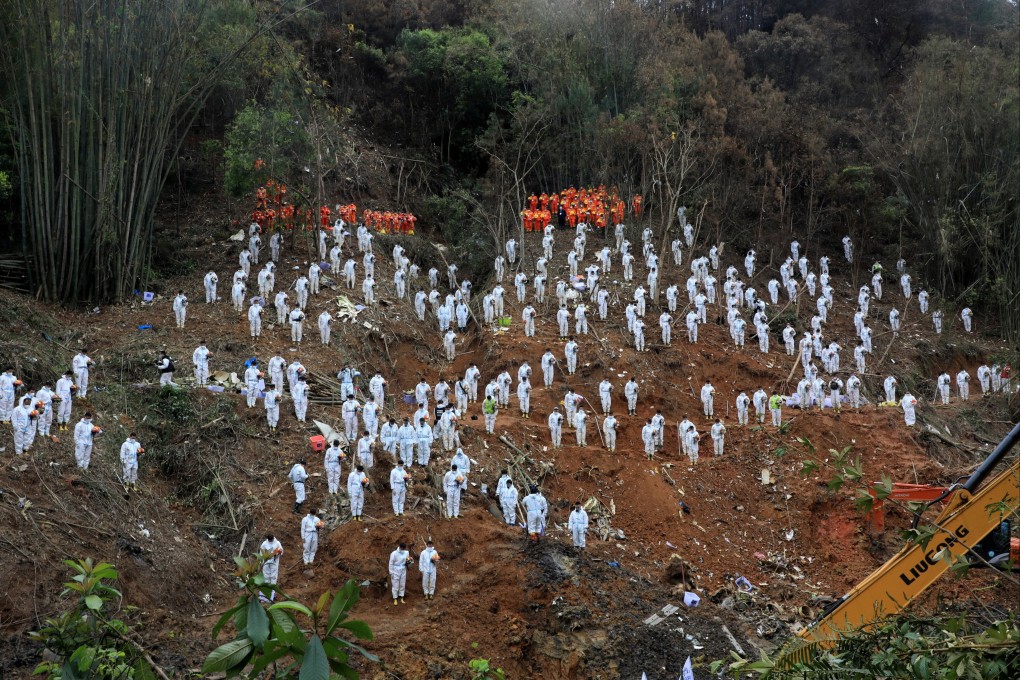 Rescue workers stand in a silent tribute at the crash site in Wuzhou, Guangxi Zhuang autonomous region on Sunday. Photo: Reuters