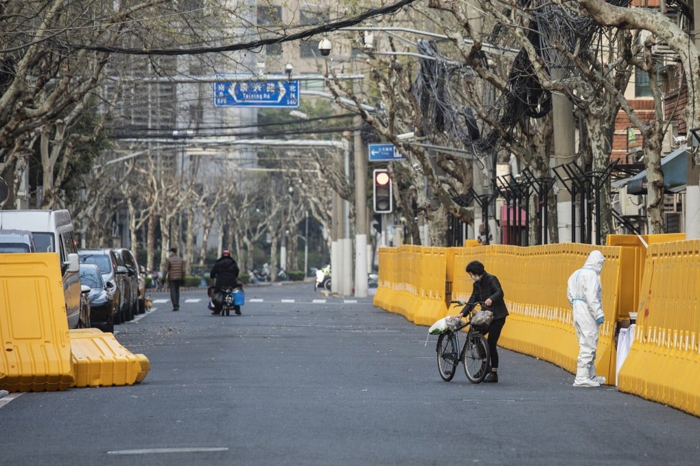 A woman on a bike brings vegetables to be delivered through the perimeter wall of a neighbourhood placed under lockdown due to Covid-19 in Shanghai on March 26. With the Chinese economy showing signs of slowing, any efforts to ramp up growth will be at the expense of domestic price stability. Photo: Bloomberg