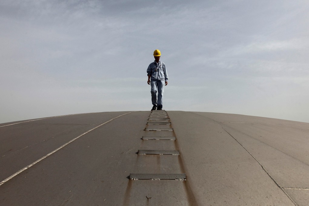 An employee walks on top of an oil tank at a Sinopec refinery in Wuhan in this file photo from April 2012. The refiner says it will pay 80 per cent of its 2021 profits to shareholders through dividend. Photo: Reuters