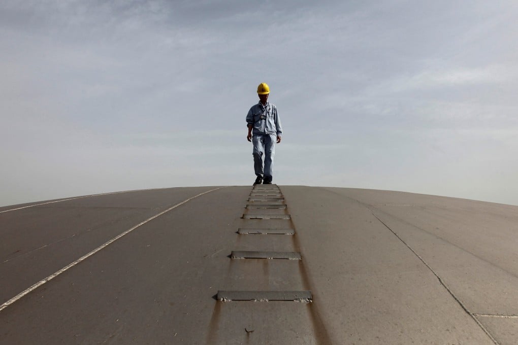 An employee walks on top of an oil tank at a Sinopec refinery in Wuhan in this file photo from April 2012. The refiner says it will pay 80 per cent of its 2021 profits to shareholders through dividend. Photo: Reuters