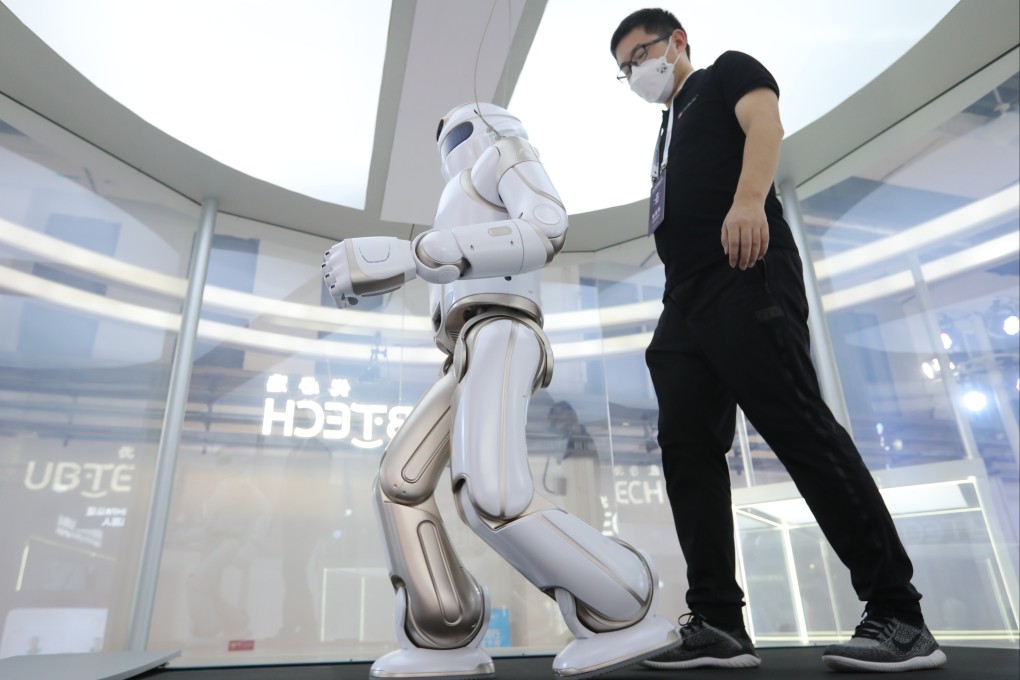 A man walks with a robot at the 2021 World Robot Conference in Beijing. Photo: Simon Song