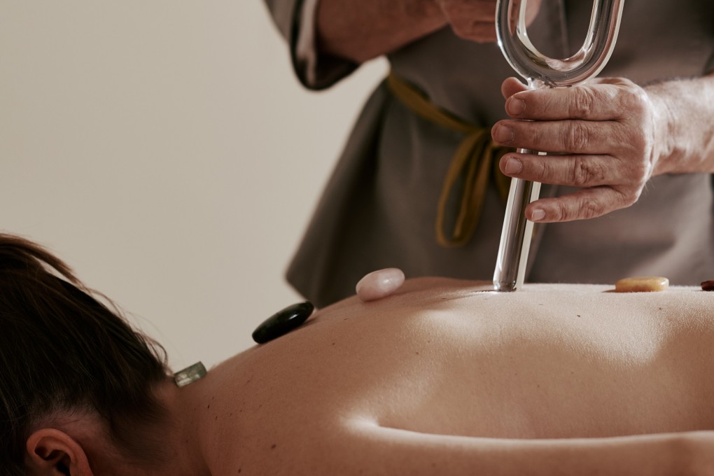 A therapist uses a crystal tuning fork during a sound healing session at The Alpina Gstaad in Gstaad, Switzerland, one of a number of new wellness trends available at the hotel.