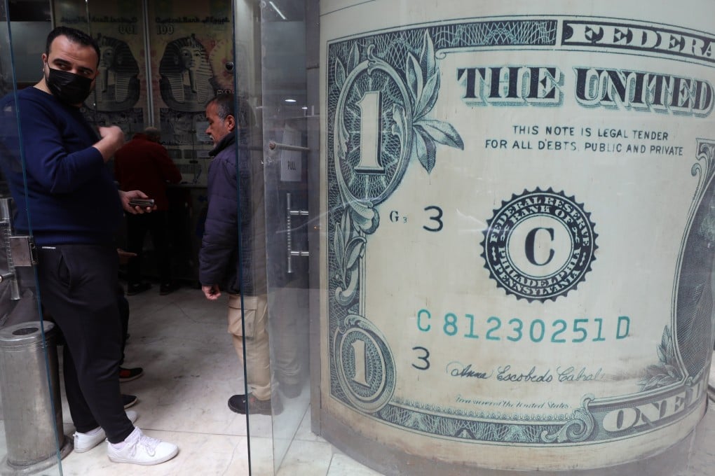 Egyptians wait at a currency exchange office in Cairo on March 22. The US dollar continues to serve a valued purpose as a freely exchangeable currency recognised in practically every country. Photo: EPA-EFE