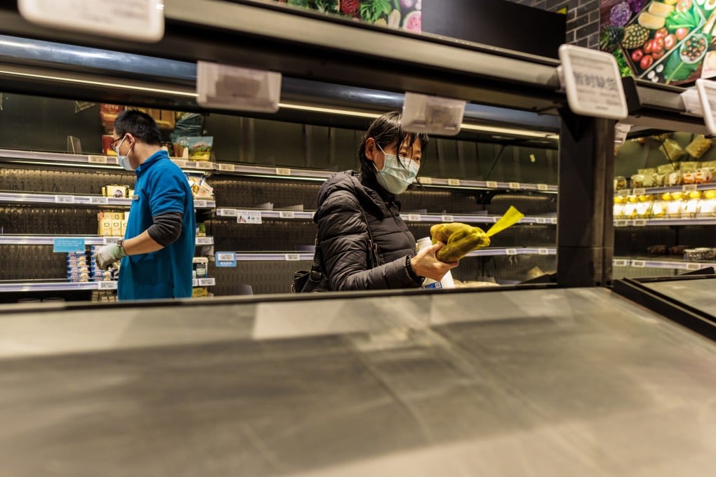 A resident in a mostly empty supermarket in Shanghai on 25 March 2022. Photo: EPA-EFE