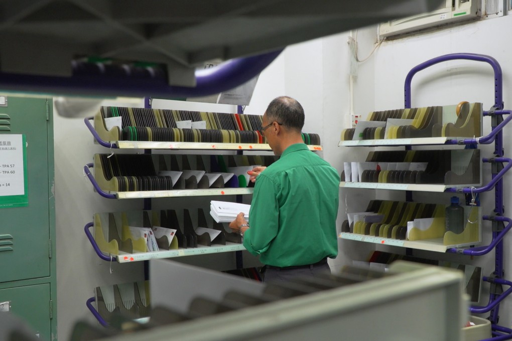 A postal worker sorts letters at the Tai Po Delivery Office on July 12, 2018. Photo: SCMP