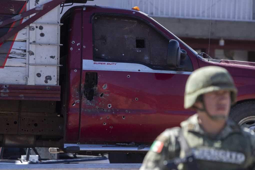 A soldier stands near a bullet ridden truck after a shootout in Parangaricutiro, Mexico. Photo: AP
