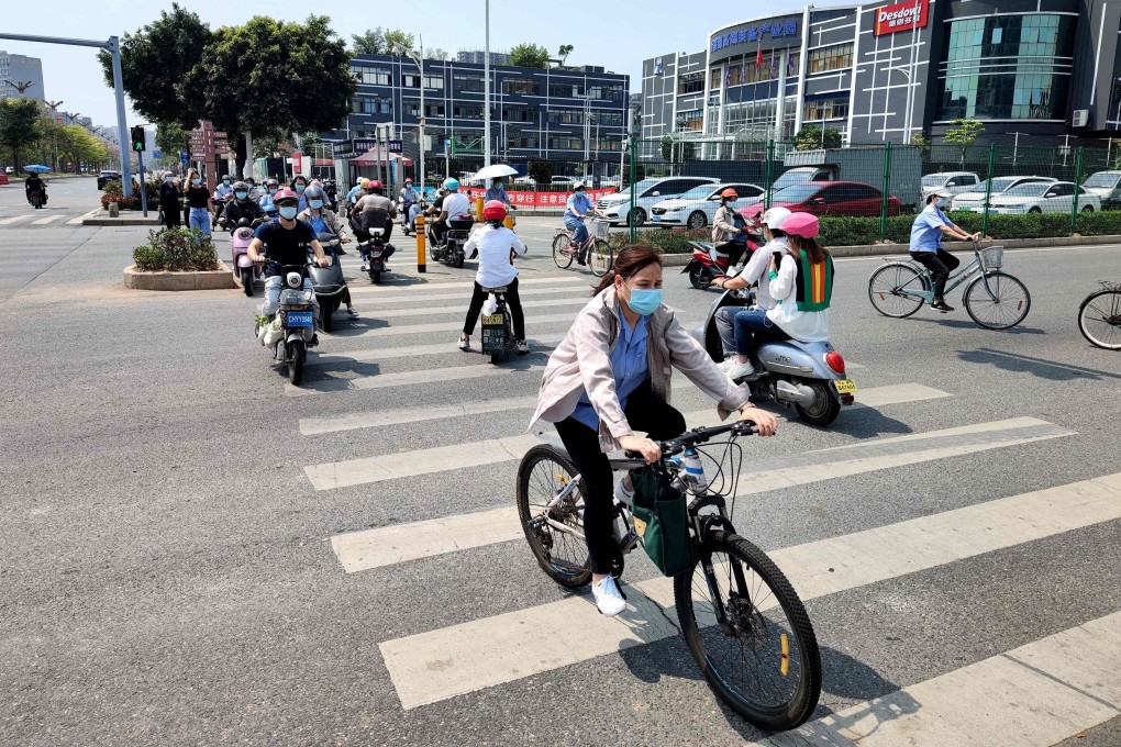 Residents of Shenzhen are seen riding scooters and bicycles along a street, as the city reopened after a week-long lockdown in March. Photo: Agence France-Presse