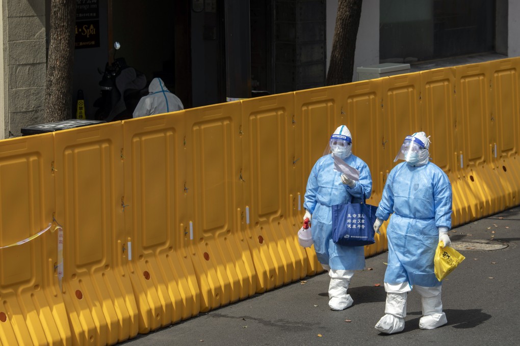 Workers in a neighbourhood under lockdown in Shanghai. There is growing discontent over the response to the latest wave of infections. Photo: Bloomberg