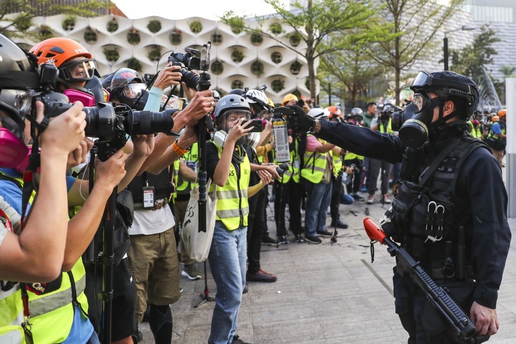 A Hong Kong police officer aims pepper spray at journalists at a rally in 2019. Photo: Sam Tsang