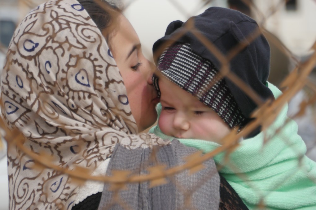 An Afghan woman holds her child as she leaves the country  at Islam Qala, a town along the border with Iran in the western Herat province of Afghanistan, on March 3. Photo: Xinhua