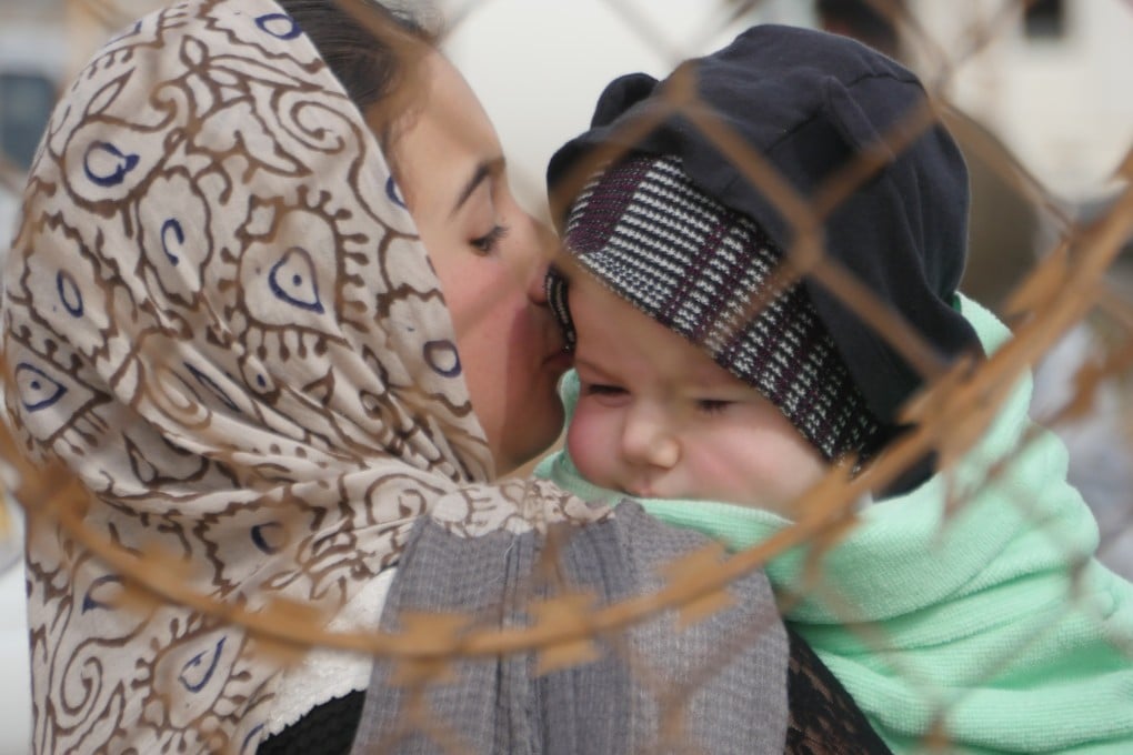 An Afghan woman holds her child as she leaves the country at Islam Qala, a town along the border with Iran in the western Herat province of Afghanistan, on March 3. Photo: Xinhua