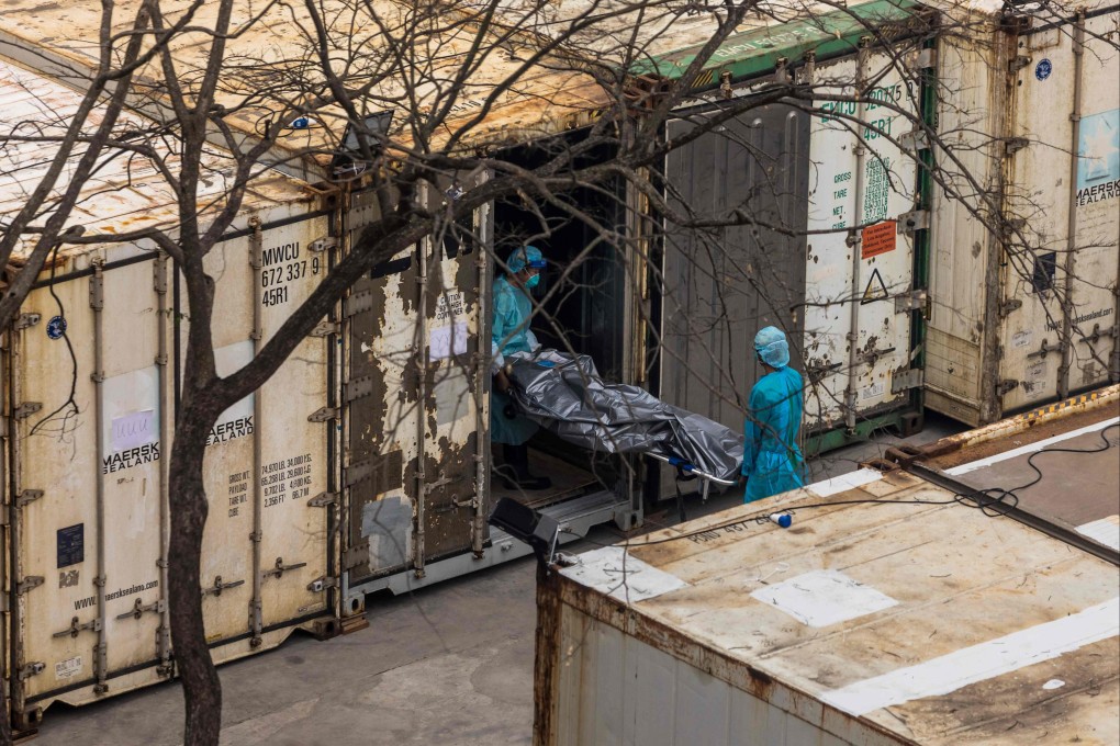 Workers move the body of deceased person from a truck into a refrigerated container at the Fu Shan Public Mortuary in Hong Kong on March 16. Photo: AFP