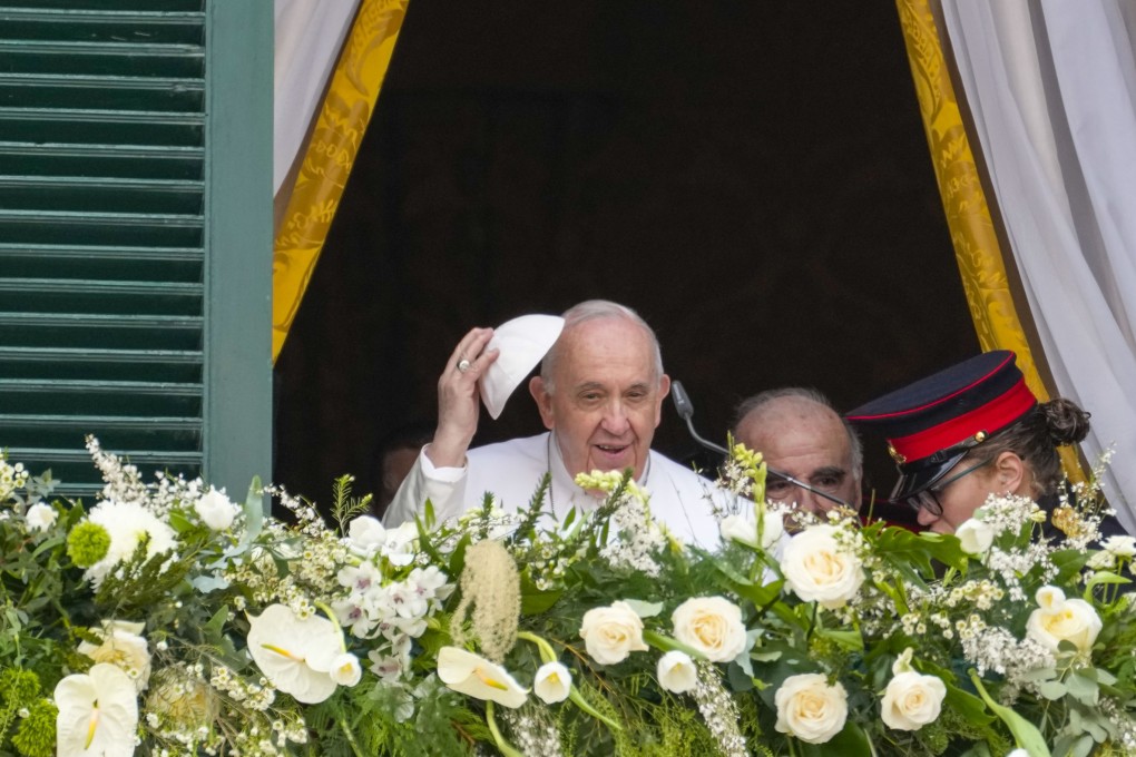 Pope Francis removes his skull cap as he appears with Malta’s President George William Vella on a palace balcony in Valletta, Malta, on Saturday. Photo: AP