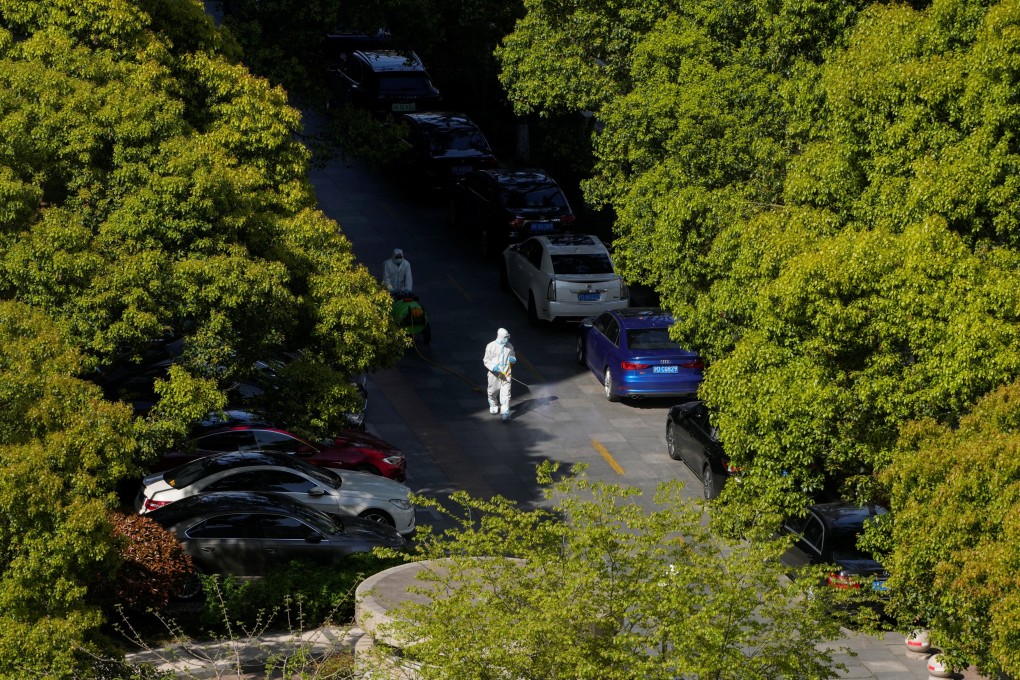 A worker in a protective suit sprays disinfectant in a community, during the second stage of a two-stage lockdown to curb the spread of Covid-19 in Shanghai. Photo: Reuters