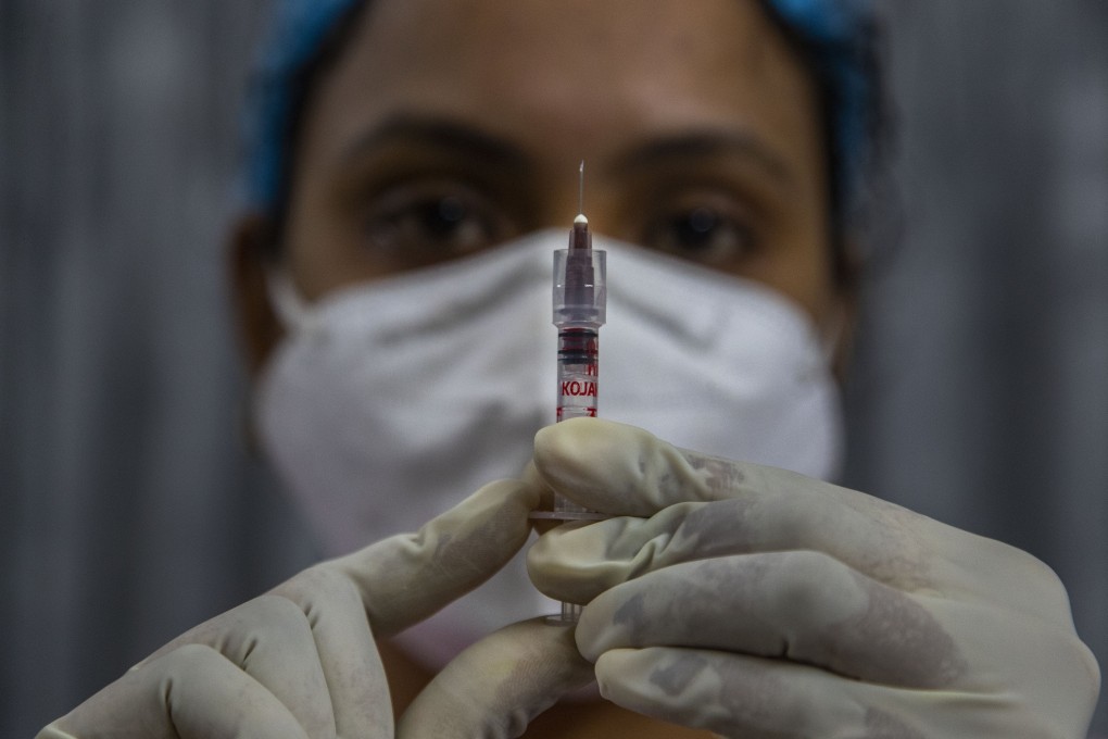 A health worker checks a syringe before administering a vaccine in India. Photo: AP Photo