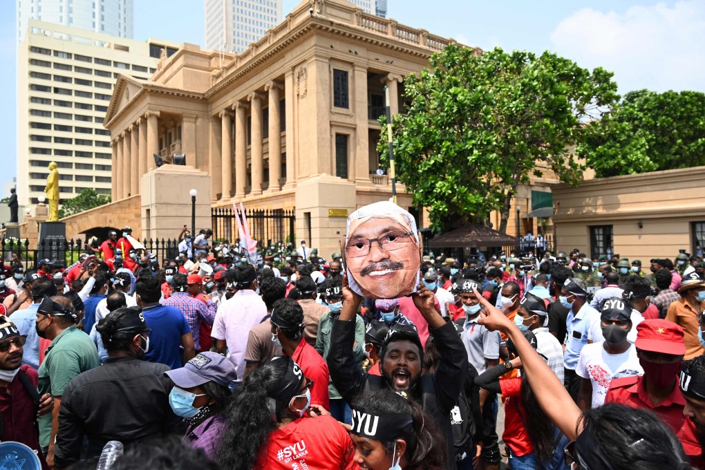 A leftist activist wearing masks of Sri Lanka’s President Gotabaya Rajapaksa (C) takes part with others in a protest against rising living costs in Colombo on March 18, 2022. Photo: AFP