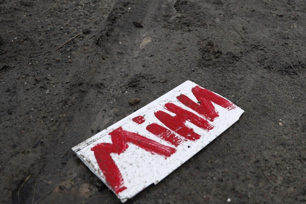 A Ukrainian sign reading ‘mines’ near a village at the frontline. Photo: EPA