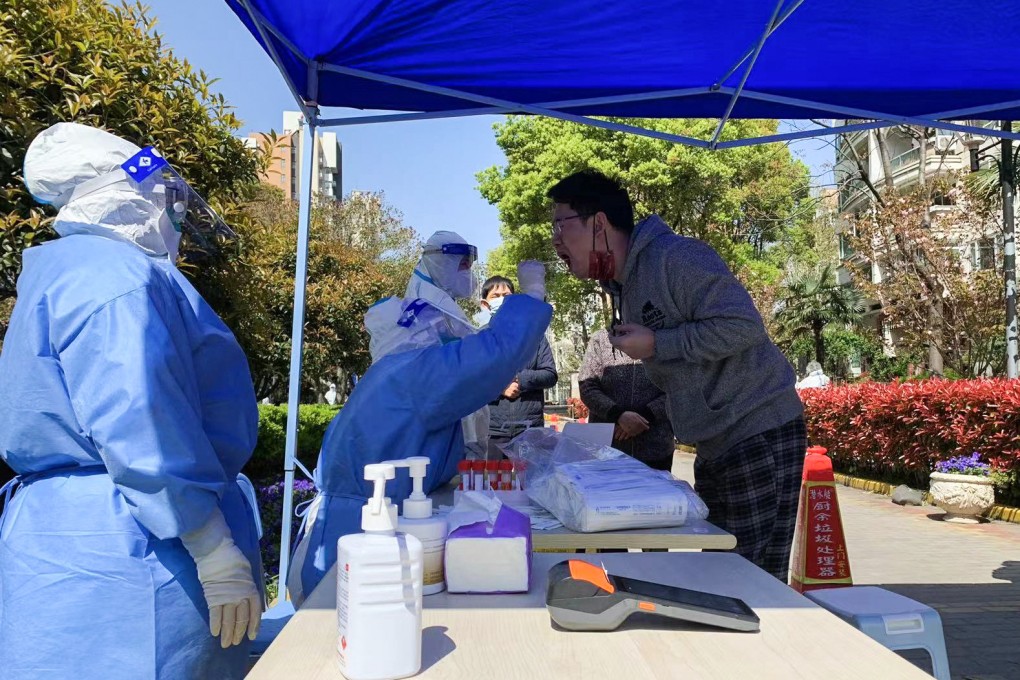 Nurses collect throat swab samples from residents of Tangqiao street in Pudong on Monday morning as part of Shanghai’s massive three-day exercise to test its 25 million people for Covid-19. Photo: Daniel Ren