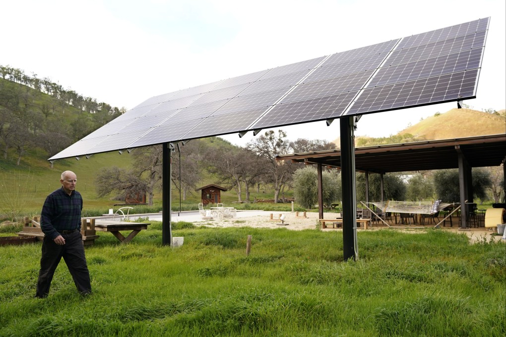Former California governor Jerry Brown walks past one of the solar panels that power his home near Williams, California. Photo: AP