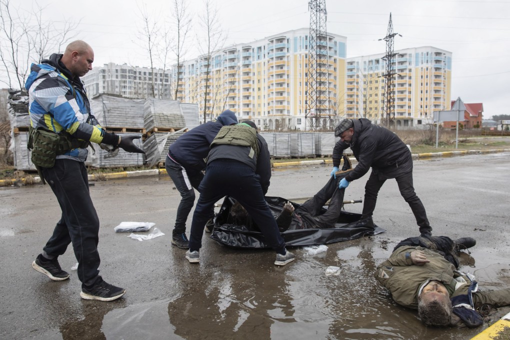 Volunteers take away bodies of Ukrainians killed on a street in Bucha in the Kyiv region. Photo: EPA