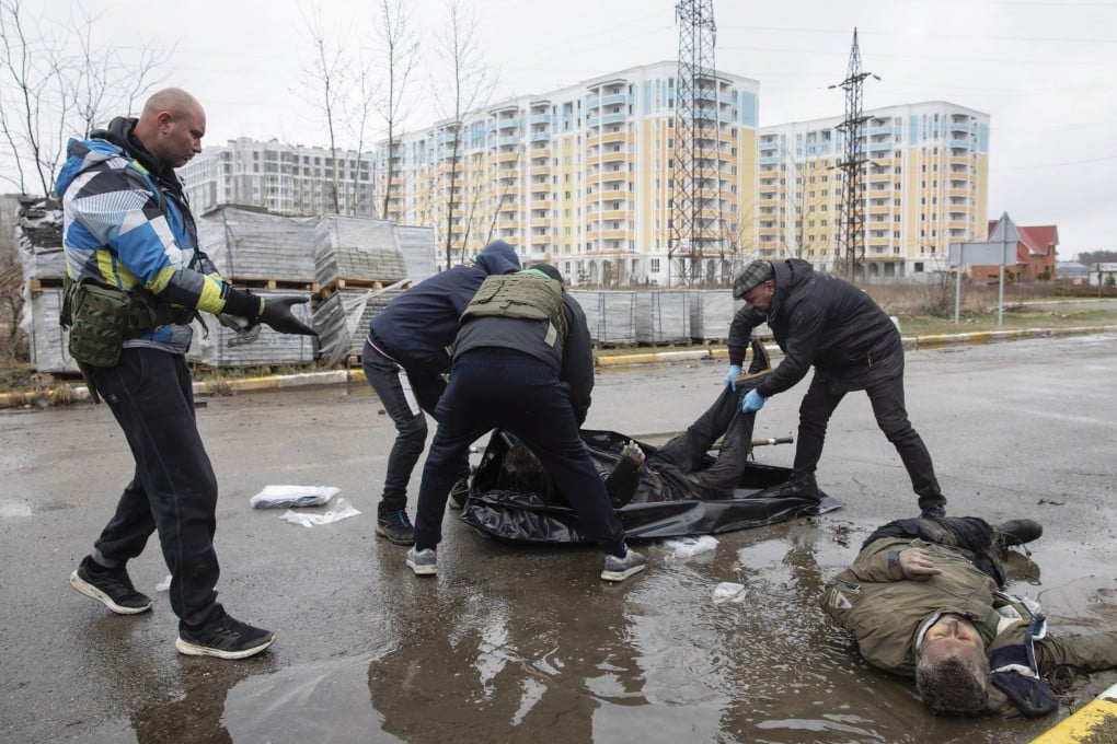 Volunteers take away bodies of Ukrainians killed on a street in Bucha in the Kyiv region. Photo: EPA