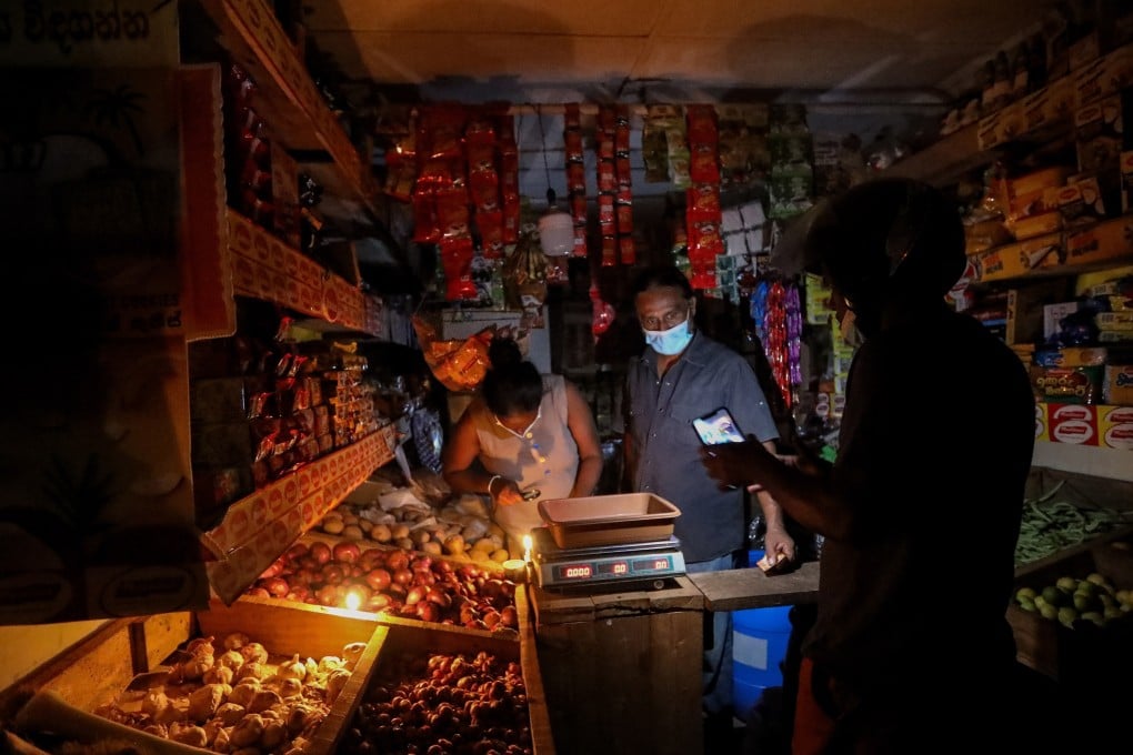 A shop in Colombo is seen illuminated by candlelight amid power cuts lasting up to 13 hours a day in Sri Lanka. Photo: EPA-EFE