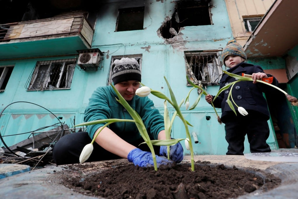 Mariupol resident Viktoria Mukhina plants tulips with her daughter on Monday. The Red Cross is still hoping to reach the Ukrainian city to help thousands of people trapped there evacuate safely. Photo: Reuters