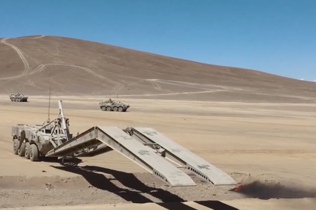 A mobile assault bridge vehicle spans a trench to let light infantry tanks from the Xinjiang Military District cross during a joint operation drill. Source: CCTV