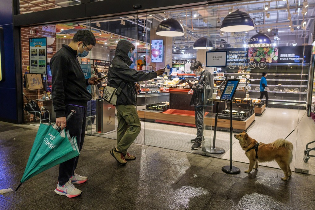 Customers scan their health QR codes before entering a grocery store, in Shanghai, China, 25 March 2022. Photo: EPA-EFE