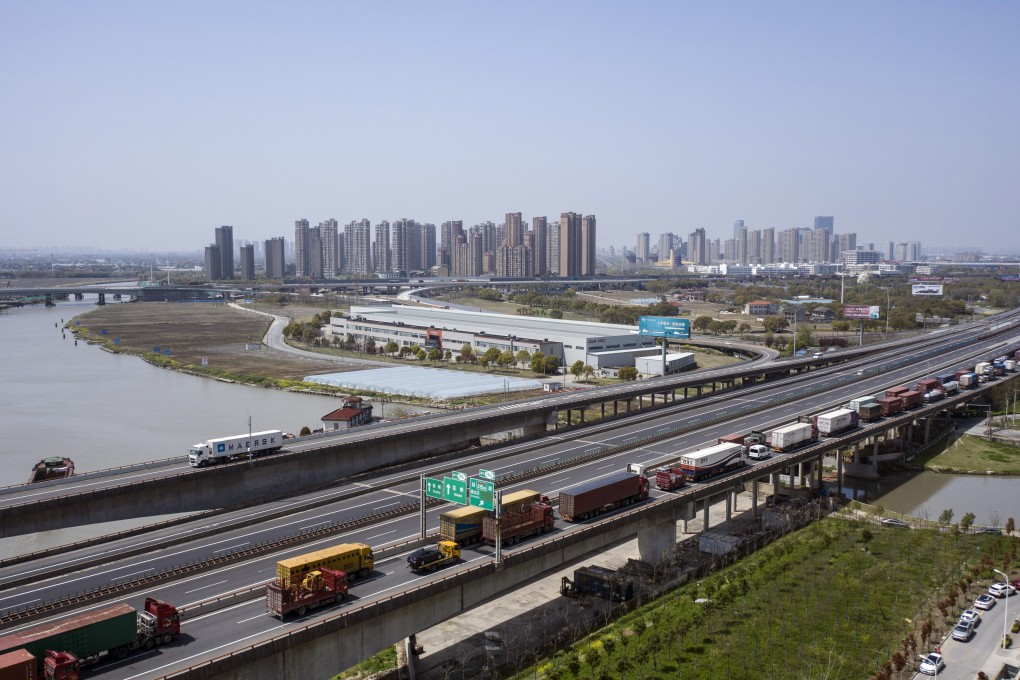Trucks wait to pass through a checkpoint on a highway leading from Shanghai. Photo: Bloomberg