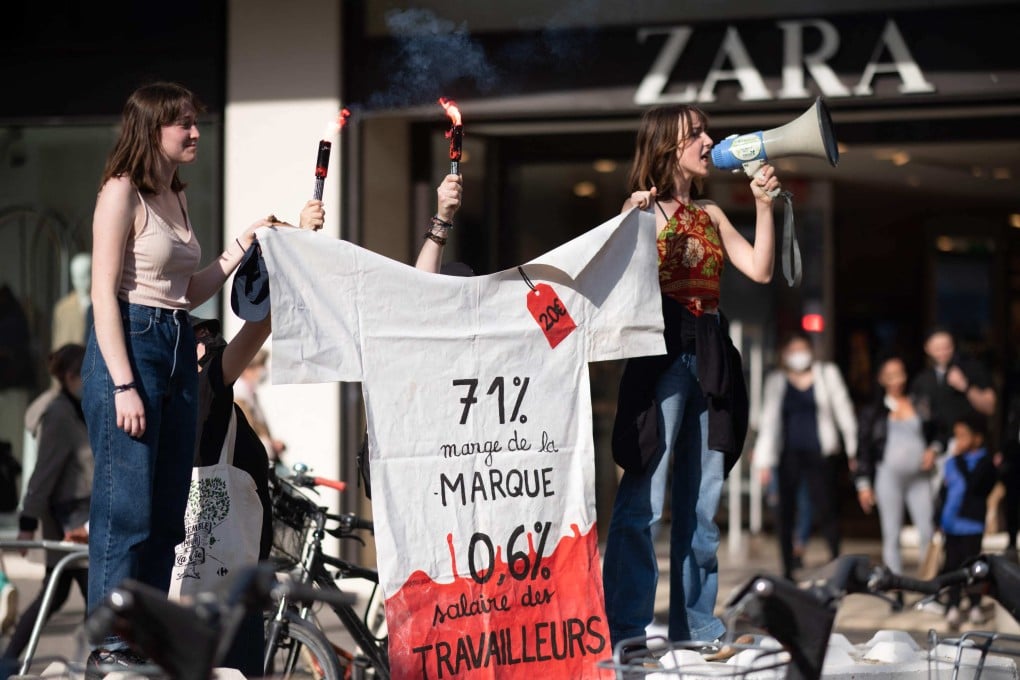 Gen Z protesters hold a T-shirt-shaped banner reading “71 per cent of brand profits, 0.6 per cent workers’ salaries” in front of a Zara retail shop as part of an international youth climate action day in Nantes, France, on March 25, 2022. Photo: AFP