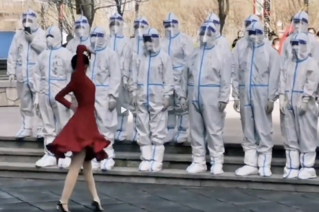 A woman dances in front of a line of pandemic workers in China, which has become common as the country battles Covid-19. Photo: Weibo