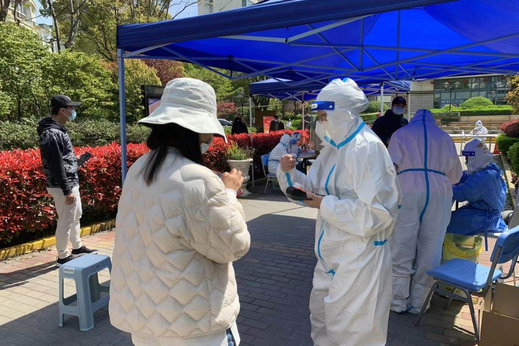 Covid-19 testing staff collect throat swab samples from residents at a residential compound at Tangqiao in Shanghai’s Pudong New Area on April 6. Photo: Daniel Ren