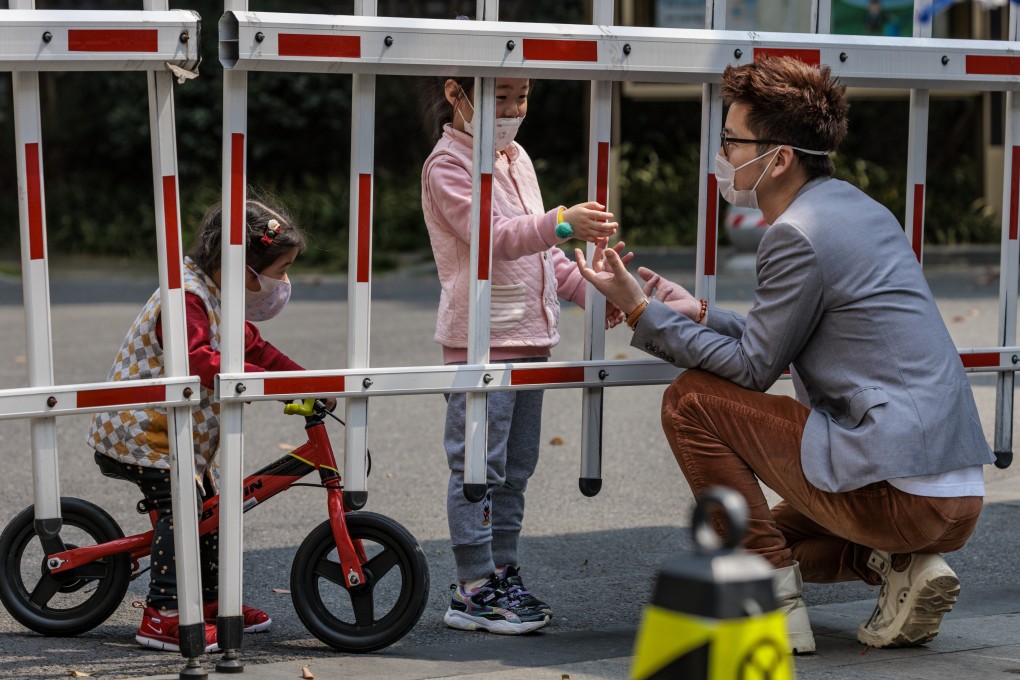 A man talks to his daughter through a fence at a residential compound under Covid-19 quarantine in Shanghai last month. Photo: EPA-EFE