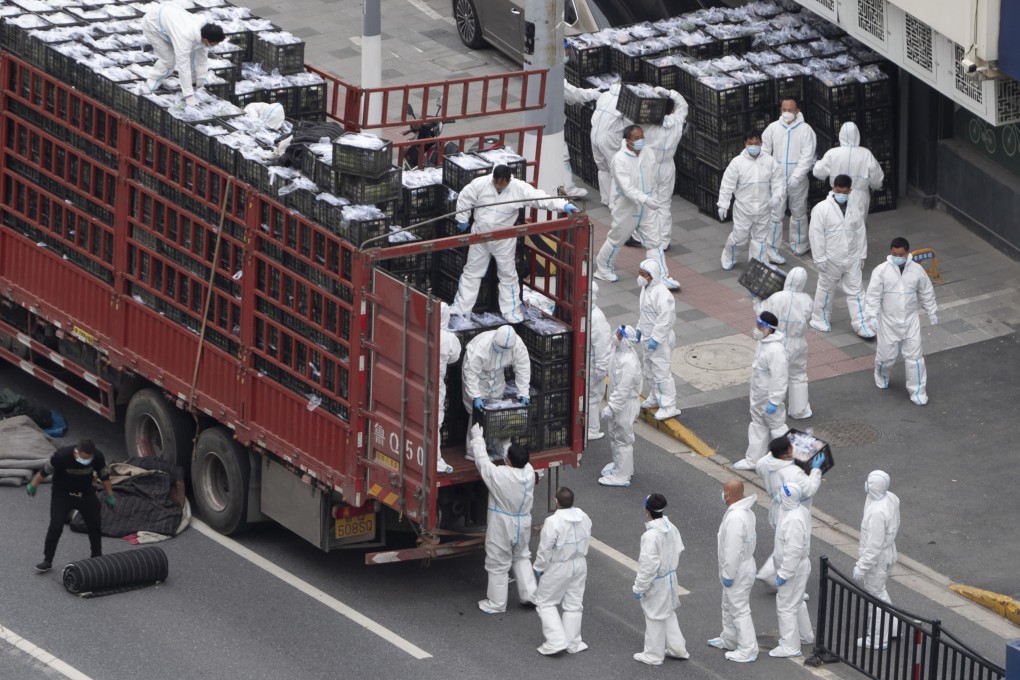 Workers unload groceries from a truck before distributing them to local residents under the COVID-19 lockdown in Shanghai on Tuesday, April 5, 2022. Photo: Chinatopix Via AP