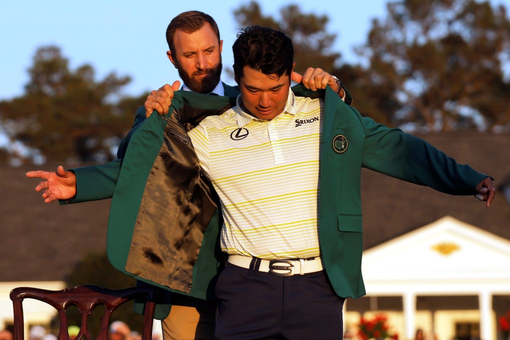 Hideki Matsuyama is presented with the green jacket by Dustin Johnson after winning The Masters in 2021. Photo: Reuters