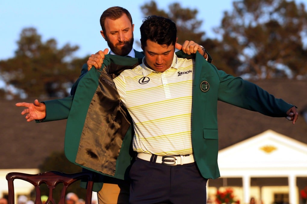Hideki Matsuyama is presented with the green jacket by Dustin Johnson after winning The Masters in 2021. Photo: Reuters