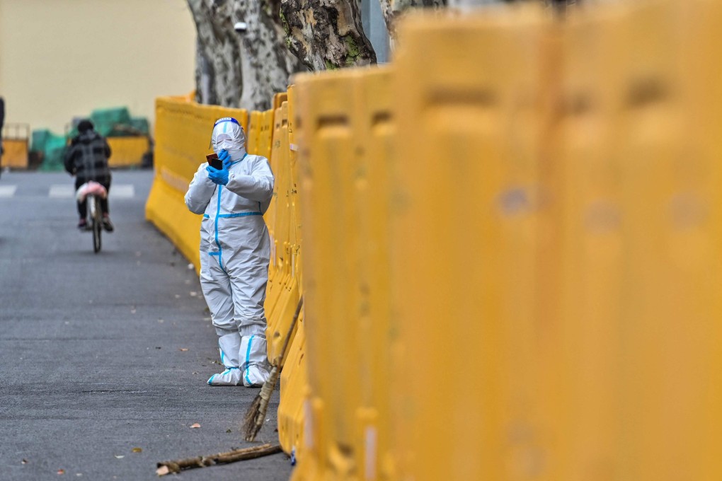 A worker wearing a protective gear stands next to barriers during Shanghai’s widespread lockdown. Photo: AFP