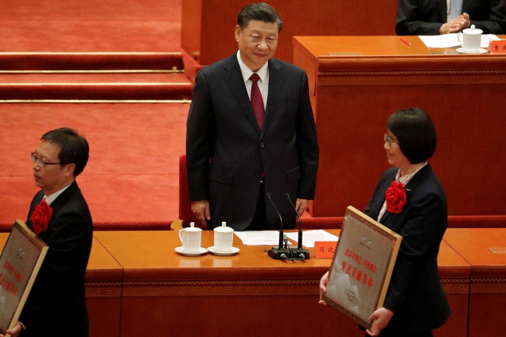 Awardees walk past Chinese President Xi Jinping at a ceremony to commend the Beijing Winter Olympics and Paralympics. Photo: Reuters