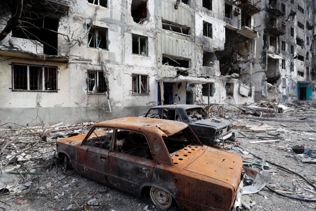 Remains of cars are seen in front of an apartment building destroyed during Ukraine-Russia conflict in the southern port city of Mariupol, Ukraine on Sunday. Photo: Reuters