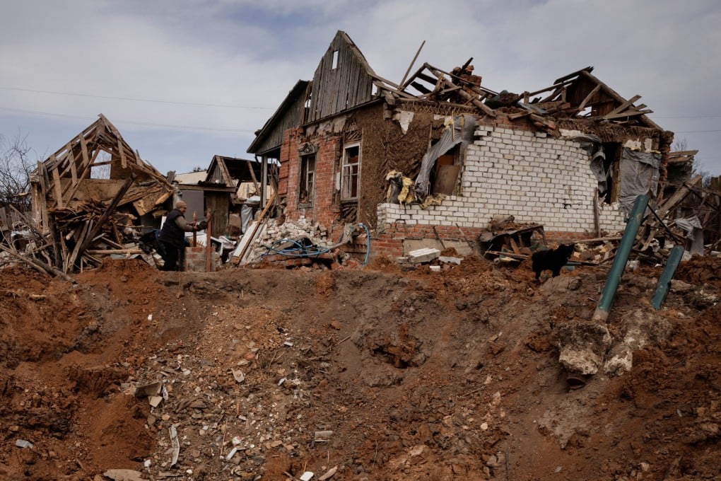 A woman draws water from her well after a Russian aerial bomb exploded outside her farm, severely damaging her home, in the village of Yakovlivka outside Kharkiv, Ukraine, on April 2. Photo: Reuters