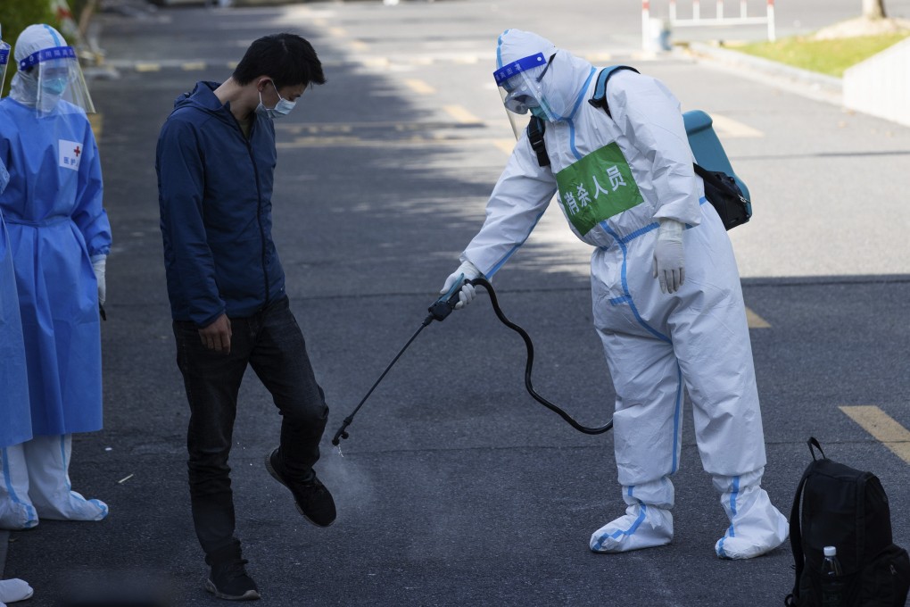 A patient who recovered from Covid-19 is disinfected as he leaves a makeshift hospital in Shanghai, April 9, 2022. Photo: Xinhua via AP