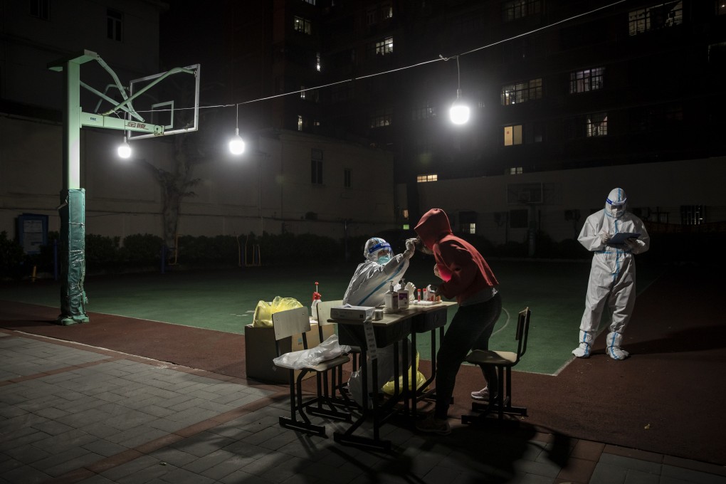 A worker in personal protective equipment collects swab sample in a neighborhood placed under lockdown in Shanghai. Photo: Bloomberg