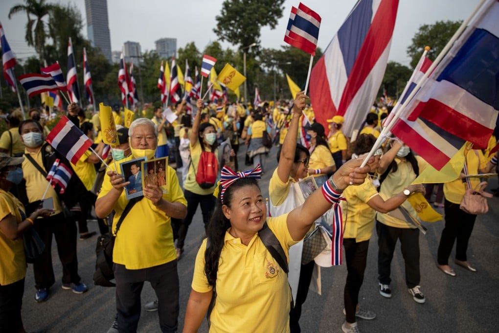 Supporters of the Thai monarchy wave national flags and display images of King Maha Vajiralongkorn, Queen Suthida and the late King Bhumibol Adulyadej during a rally in Bangkok in 2020. Photo: AP